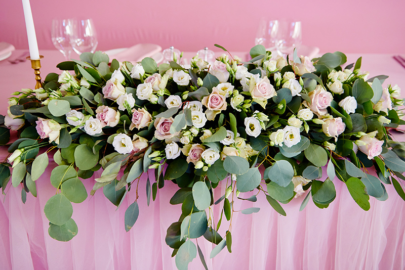 Arreglo floral horizontal en una mesa de boda